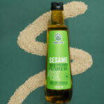COLD PRESSED FILTERED SESAME OIL 1 L with sesame seeds in the background creating S