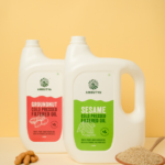 Amrutva Cold Pressed Sesame and Groundnut Oil Combo. This image shows two bottles of cold pressed oil; one sesame and one groundnut; alongside their respective raw ingredients. This combo offer provides a healthy and flavorful option for cooking.