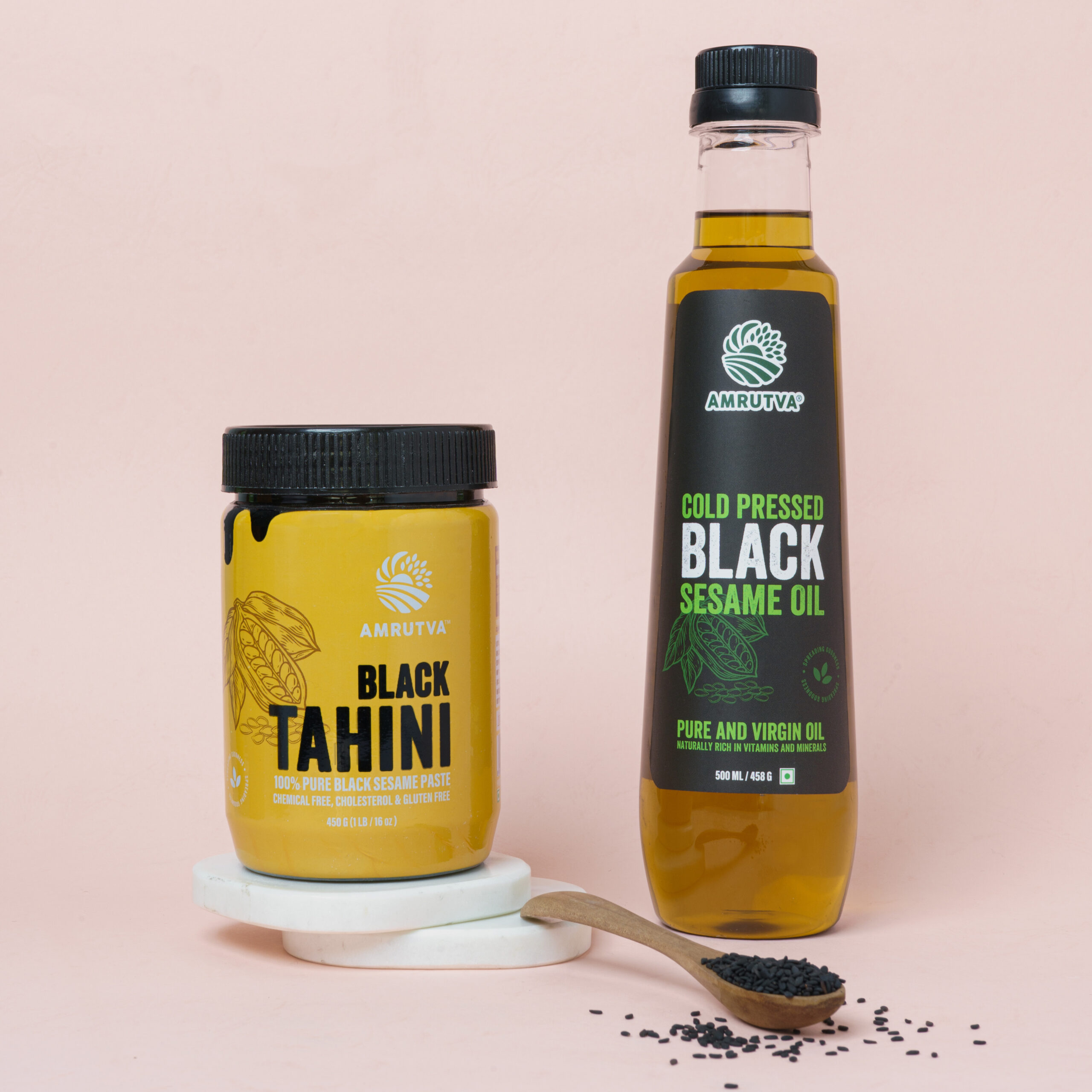 black sesame oil and black tahini with some black sesame seeds sprinkled around the bottles as its made by sesame seeds black