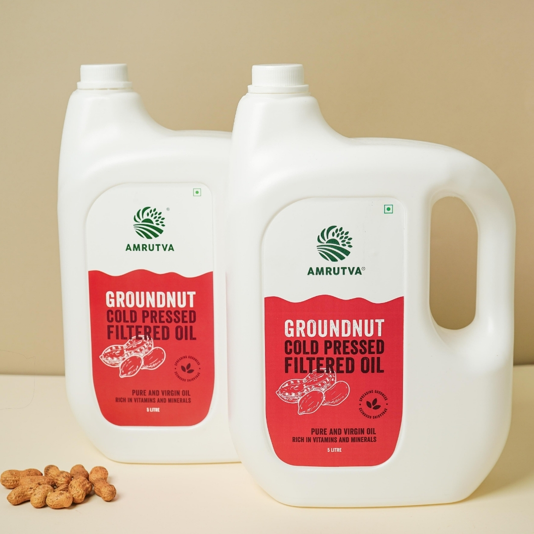 2 pet bottles of cold pressed groundnut oil filtered pack of 2 with some peanuts near the bottle